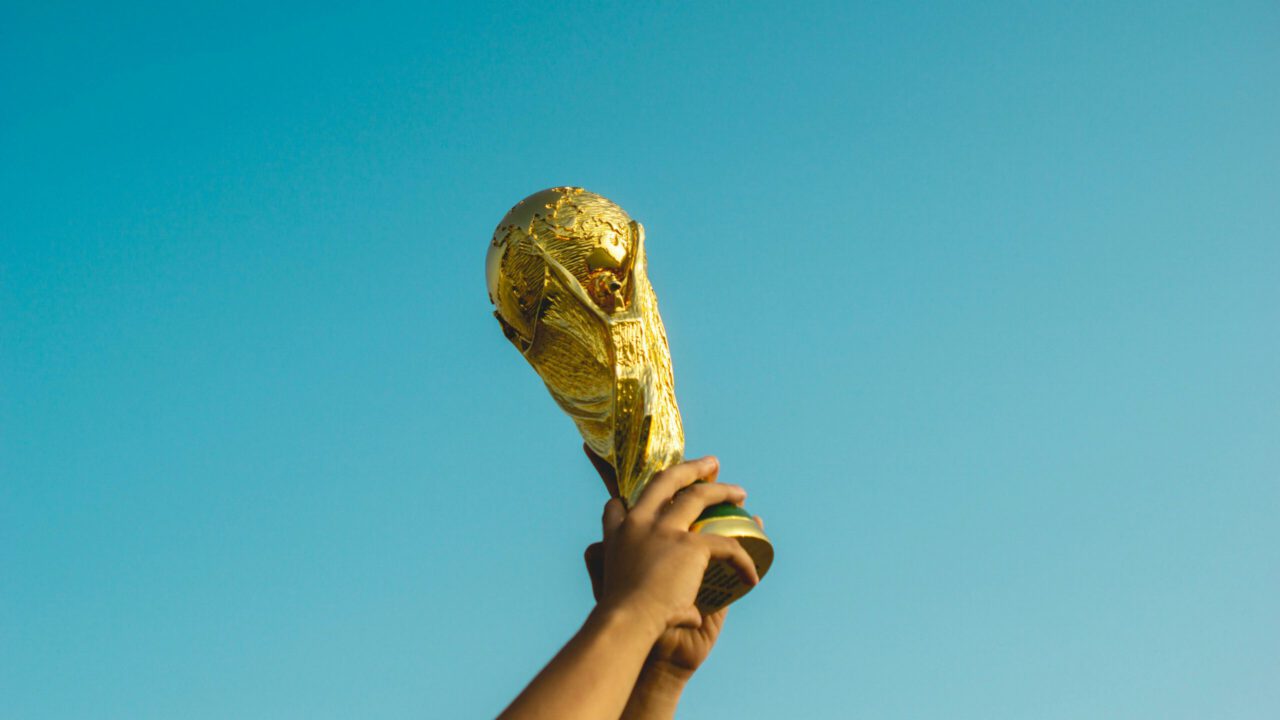 Hände heben einen Pokal in die Luft