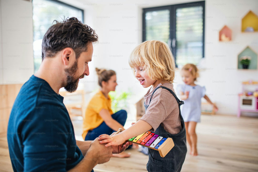 Ein Mann musiziert im Kindergarten mit einem Mädchen